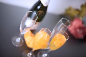 four wine glasses with orange juice and a bottle of wine at Hotel Toboso Chaparil in Nerja