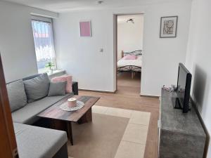 a living room with a couch and a table at Gemütliche Wohnung im Gutshaus in Lalendorf