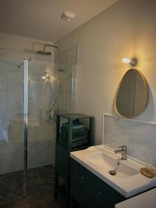 a bathroom with a sink and a shower with a mirror at L'Escale de la Râperie, logement 3 in Tincourt-Boucly +5 photos
