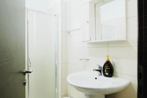 a white bathroom with a sink and a mirror at Sunny View Apartment in Sarandë +22 photos