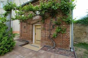 a brick building with a door and a tree at Apartmán Trojan in Hrušky