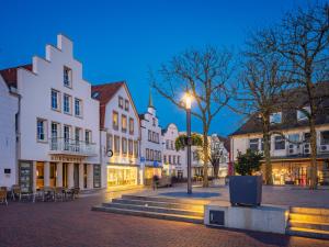 a town square with buildings and a street at night at Markt22 - Exklusive Stadtapartments in Lingen