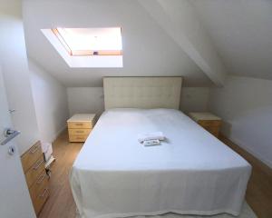 a bedroom with a large white bed with a skylight at CV017 - Milano Marittima, elegante mansarda con aria condizionata in Cervia