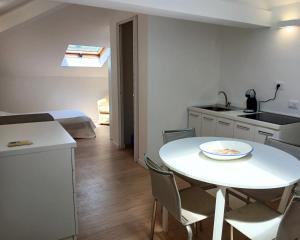 a small kitchen and a white table in a room at CV017 - Milano Marittima, elegante mansarda con aria condizionata in Cervia