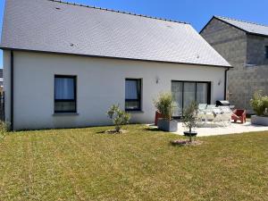 a white house with a yard with chairs at La Belle de Fréhel - Jolie maison avec jardin in Frehel