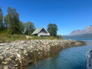 トロムソにあるSjursnes, Lyngen alps, Aurora borealisの水辺にある家
