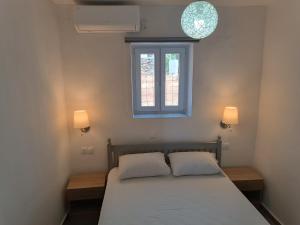 a bedroom with a bed with two pillows and a window at Silver View Aprovato in Apróvaton