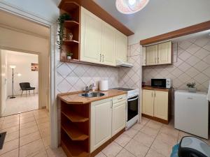a kitchen with white cabinets and a sink at CalvinForumGreatChurchMainSquare in Debrecen +16 photos