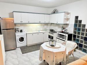 a kitchen with white cabinets and a table in it at Elaia Stay in Nea Vrasna