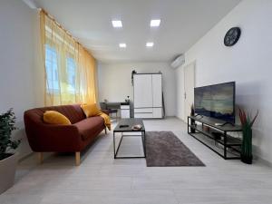 a living room with a couch and a tv at CalvinForumGreatChurchMainSquare in Debrecen