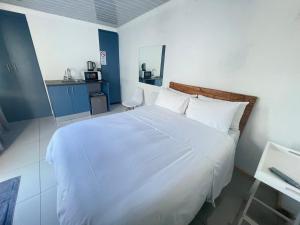 a bedroom with a large white bed and a kitchen at Drifters Haven Gqeberha in Gqeberha +17 photos