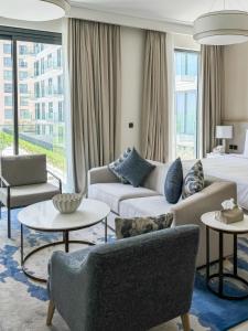 een woonkamer met een bank en een bed bij Marrasi Vista by the address in Muharraq