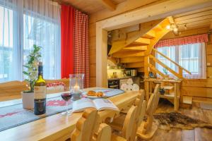 a dining room with a table with a bottle of wine at Chata Aleksandra in Zakopane