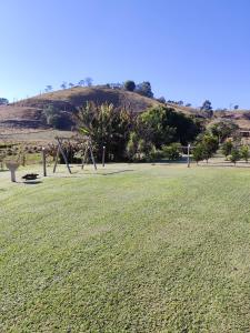 ein großes Grasfeld mit einem Hügel im Hintergrund in der Unterkunft Pousada Campestre Cunha-SP in Cunha