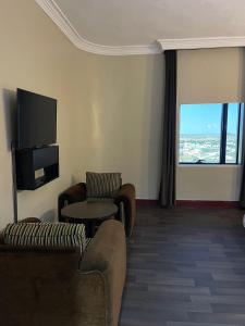 a living room with a couch and a tv at فندق زهوان للضيافة السياحي in Al Buwaţah