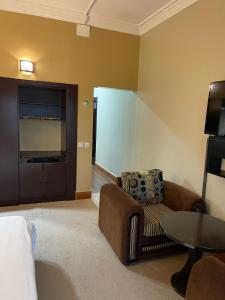 a living room with a couch and a table at فندق زهوان للضيافة السياحي in Al Buwaţah