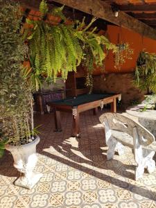 eine Tischtennisplatte und eine Bank im Innenhof in der Unterkunft Pousada Campestre Cunha-SP in Cunha