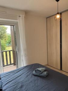 a bedroom with a bed and a large window at CAPUCINES - T2 ANGLET avec stationnement in Anglet