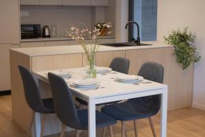 a white table with chairs and a vase of flowers on it at Hotel Taxis Bratislava - Suites in Bratislava