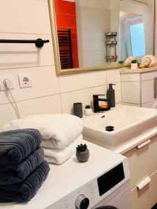 a bathroom with a sink and a mirror and towels at Sea View Beachfront Apartment Maslina in Omiš