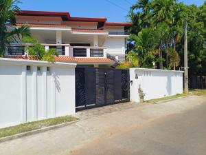 a house with a white fence and a gate at JarushanInnHotel in Jaffna