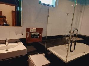 a bathroom with a shower and a toilet and a sink at JarushanInnHotel in Jaffna