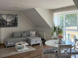 a living room with a couch and a table at Apartmán pri parku in Seredʼ