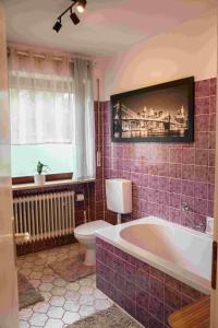 a bathroom with a tub and a toilet and a window at Ferienwohnung Winehouse - Urlaub bei der Winzerfamilie Zink in Zeil