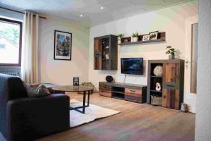 a living room with a couch and a tv at Ferienwohnung Winehouse - Urlaub bei der Winzerfamilie Zink in Zeil