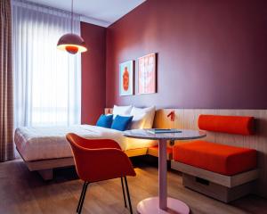 una camera con letto, tavolo e tavolo di Numa Berlin Friedrichshain a Berlino