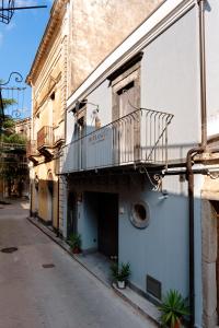a building with a balcony on the side of a street at Pietranera - Sicilian Escape Retreat in Linguaglossa