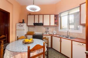 a kitchen with a table with a bowl of fruit on it at Pylos Sunset Retreat with Panoramic Sea Views in Pylos