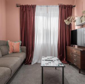 a living room with a couch and a tv at Ideal Location, 4 Beds, Mid-Century Home in Orange