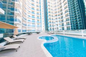 a large building with a swimming pool in front of a building at Two bedrooms in Ajman, Oasis Towers in Ajman 
