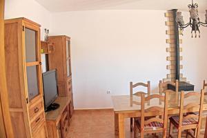 a dining room with a table and a tv at Chalet Arroyo Majadales 108 in Conil de la Frontera +10 photos