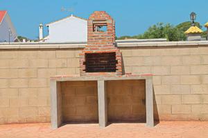 una pared de ladrillo con un pequeño horno de ladrillo encima en Chalet Arroyo Majadales 108, en Conil de la Frontera