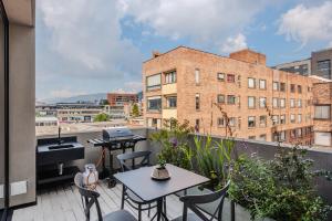 a balcony with tables and chairs on a building at 79bogotá Boutique Suites in Bogotá