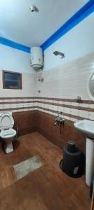 un baño con inodoro y lavabo en Coorg Relax Home, en Madikeri