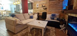 a living room with a couch and a table and a tv at Katerina Boutique Apartment in Bansko