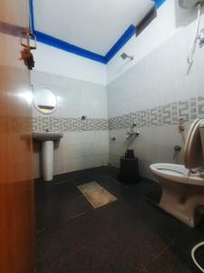 un baño con inodoro y lavabo en Coorg Relax Home, en Madikeri