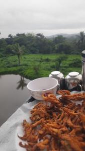 Una pila de comida en una mesa con vistas a un campo. en Coorg Relax Home, en Madikeri 7 fotos más