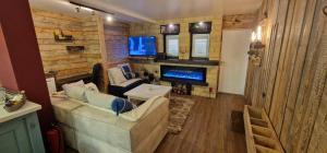 a living room with a couch and a tv at Katerina Boutique Apartment in Bansko