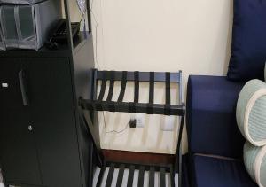 a small room with a bed next to a cabinet at Stylish New Studio at McKinley Hill BGC Free Netflix in Manila