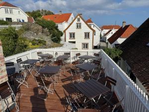 a group of tables and chairs on a deck at Lundins Hotell in Karmøy