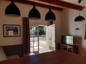 a dining room with a table and a sliding glass door at Mas jumelé 2 chambres dans cadre idyllique proximité mer in La Cadière-dʼAzur