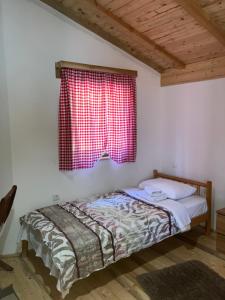 a bed in a room with a red window at Semeteška bajka in Raška +28 photos