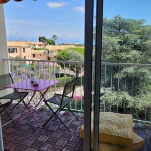 una mesa púrpura y sillas en un balcón con vistas en Chez Sandrine au Beauvallon, en Antibes
