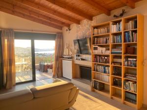 a living room with a couch and book shelves at EUPHORIA Pool Villa in Porto Rafti