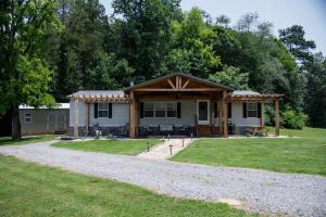 a small house with a porch and a gravel driveway at Countryside Living with a great outdoor space in Grant