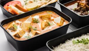 a container of food with tofu and rice on a table at kashidham home stays in Varanasi